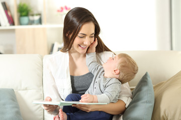 Mother and son looking each other holding a book