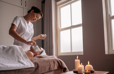 Woman receiving face mask treatment in spa