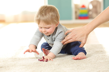 Fototapeta premium Mother hand preventing the baby from eating pills