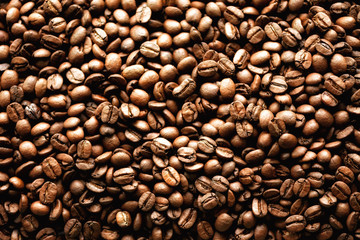Roasted coffee beans backgound, copy space, top view. Cappuccino, dark espresso, aroma black caffeine drink, ingredient for coffee beverage.