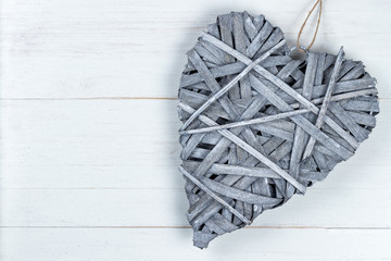 Wooden Valentines Day heart on a string on wooden background.