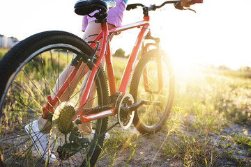 Young girl with a sports bike in the sunlight