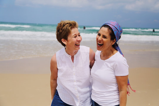 Outdoor portrait of two women standing on the beach