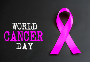 Purple ribbon awareness on black background  for World Cancer day.