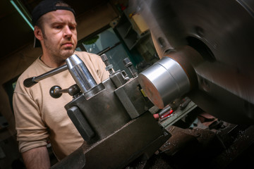 Metal worker working on lathe