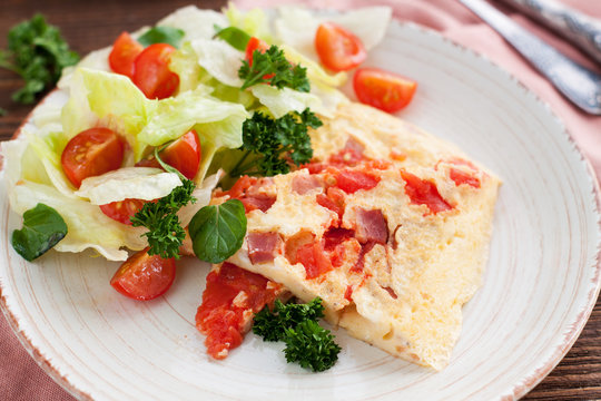 Spicy Omelet with ham, tomatoes, pepper, cheese and herbs