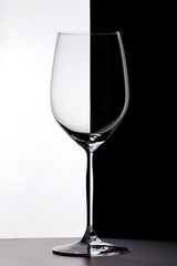 Wineglass on the border of black and white backgrounds.
