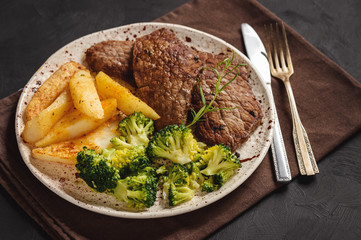 Grilled beefsteack with broccoli and  baked potatoes.