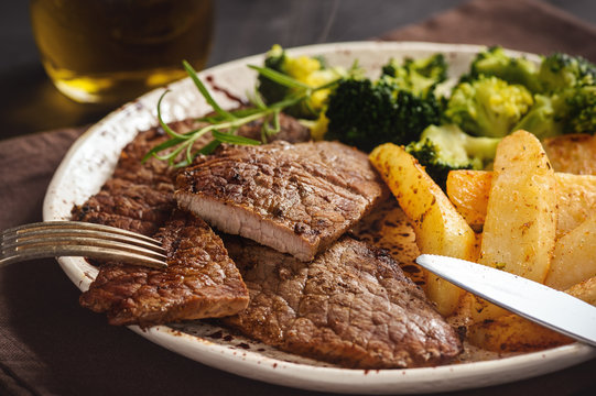Grilled beefsteack with broccoli and  baked potatoes.