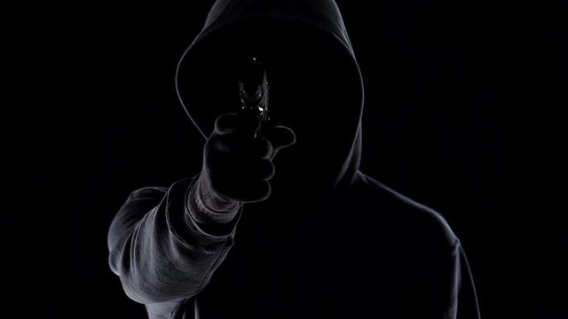 Criminal in hood cocking and shooting, murder of human, growth of crime in world