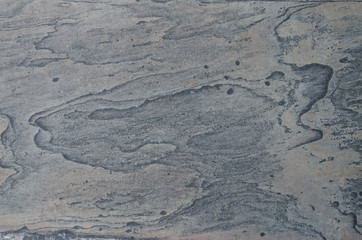 An abstract view of a flat, weathered stone surface suitable for use as a texture or background