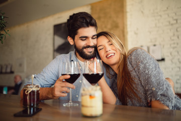 Romantic couple on date drinking red wine in cafe and celebrating anniversary or Valentine's day.