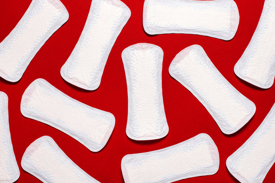 Menstruation. Pile of pads liners on red background