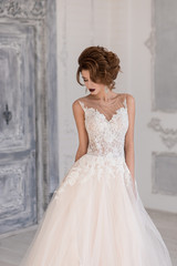 Obraz premium Morning of the bride. A beautiful bride stands in a wedding dress.