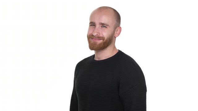 Half-turn portrait of friendly male wearing red beard and mustaches, posing on camera showing thumb up or like sign over white background. Concept of emotions