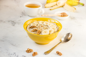 Oatmeal with banana and honey. Porridge in a yellow bowl