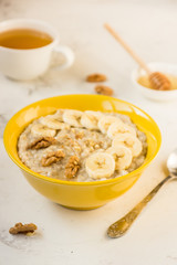 Oatmeal with banana and honey. Porridge in a yellow bowl
