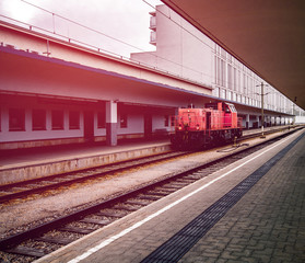 Red locomotive waiting on the rainways