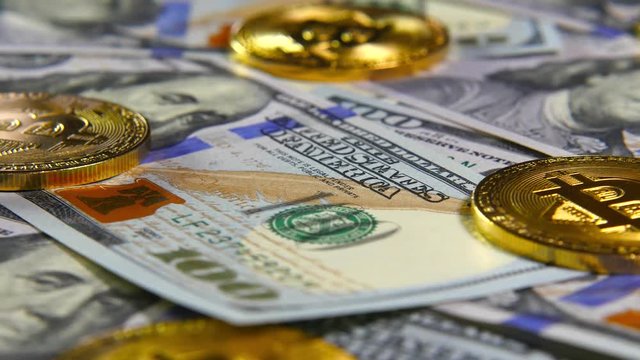 Gold coins of bitcoins and a background of hundred-dollar bills. The concept of financial operations. Economy of the future
