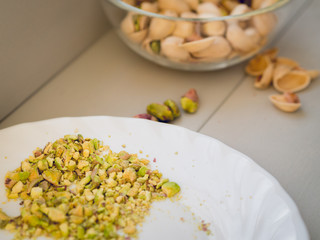 Crashed and whole pistachios on wooden board