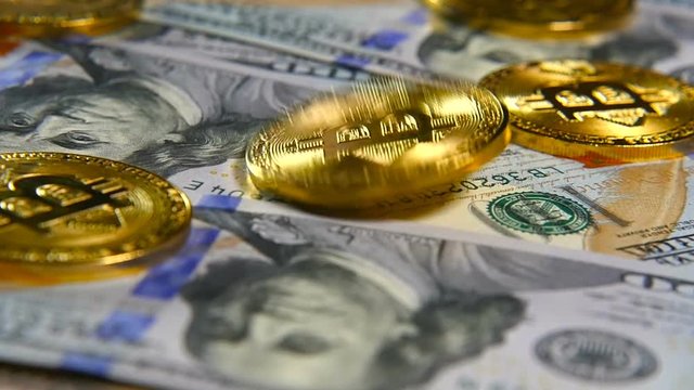 Gold coins of bitcoins and a background of hundred-dollar bills. The concept of financial operations. Economy of the future