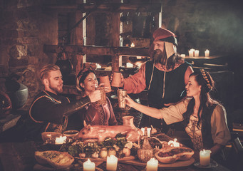 Medieval people eat and drink in ancient castle tavern