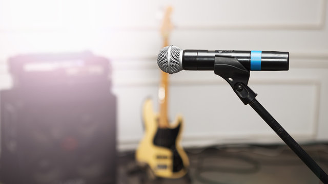 stage microphone and guitar with amplifier in background