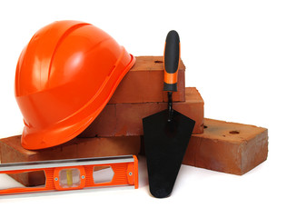 Brick, red hard hat and tools
