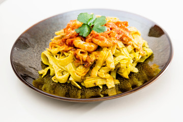 Shrimp Pasta with pesto sauce and nuts on a the table