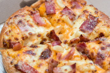 Close up of pizzas with variety of toppings and cheese in cardboard take out boxes with open lid