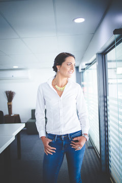 Beautiful brunette business woman standing in a boardroom