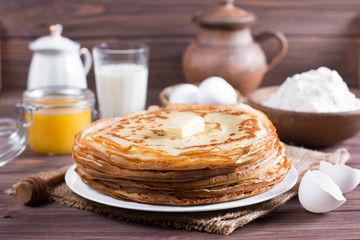 Many pancakes on a wooden background. Traditional Ukrainian or Russian pancakes. Shrovetide Maslenitsa.