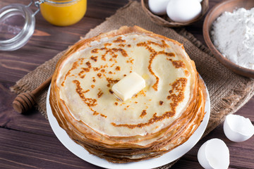 Many pancakes on a wooden background. Traditional Ukrainian or Russian pancakes. Shrovetide Maslenitsa.