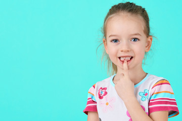 Adorable little girl smiling and showing off her first lost milk tooth. Cute preschooler portrait after dropping her front baby tooth. - obrazy, fototapety, plakaty