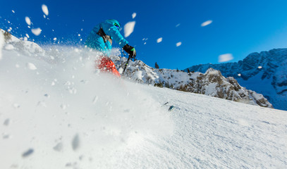 Young man freerider skiing downhill in Alps.