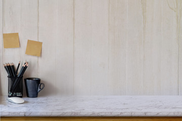 Workspace and copy space marble table top pencils and black coffee mug.