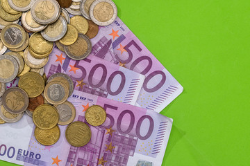 500 euro banknotes with coin on green