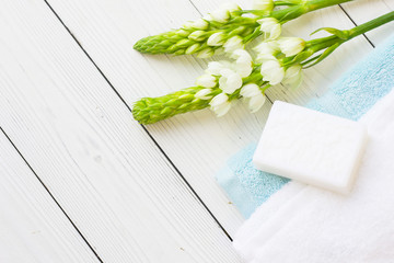 Natural Sea Spa and aromatherapy concept with blue and white towels, hand made soap and fresh white flowers on a white wooden background, top view, flat lay