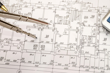 architectural construction documents with pen and calculator