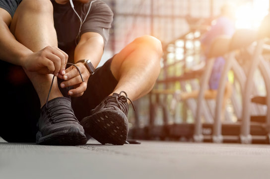 Cropped shot of a man tying his shoelaces before a workout