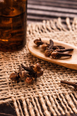 essential oil of cloves on a wooden rustic background