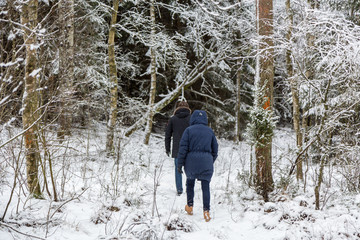 Man och kvinna vandrar i snötäckt skog