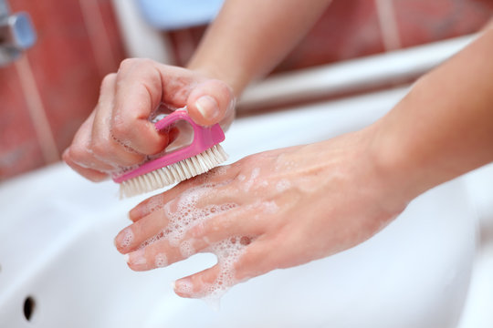 Female soapy hands with cleaning brush