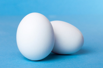 Good hearty breakfast of boiled eggs. Two white eggs on a blue background