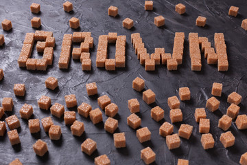 The word BROWN laid out of cubes of sugar on a black background