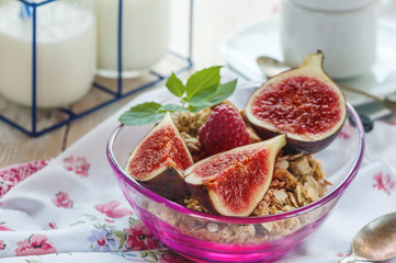 A healthy Breakfast of figs, cereals and fruit with nuts and mint. Close-up.