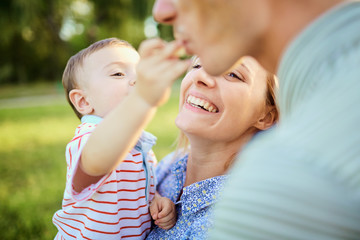 Happy family in nature. Parents with a child play in park.