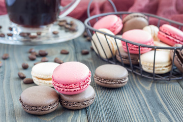 Different kinds of colorful french dessert macaron with different fillings on table, served with coffee, horizontal