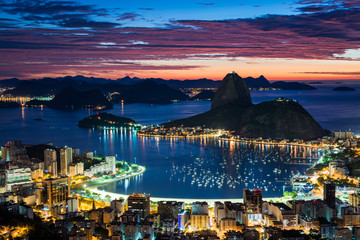 Rio de Janeiro city just before sunrise with city lights on, and the Sugarloaf Mountain in the horizon