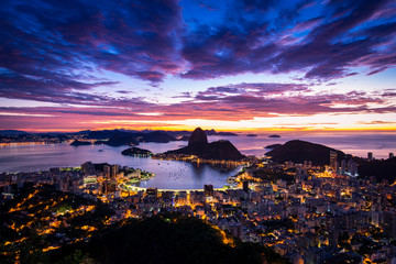 Rio de Janeiro city just before sunrise with city lights on, and the Sugarloaf Mountain in the...